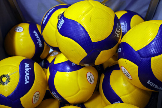 Mehrere gelb-blaue Mikasa-V200W-Hallenvolleyb&auml;lle in einem Ballkorb. Das Modell wird im professionellen nationalen und internationalen Volleyball eingesetzt.