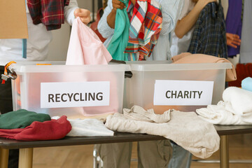young people are engaged in charity and volunteering, selecting clothes for recycling and charity - Powered by Adobe