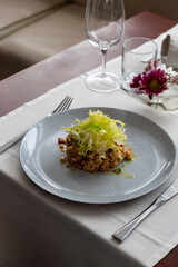 Cold Pork and Beans Salad with Escarole at Restaurant Table - Fine Dining Food and Drink in Elegant Setting