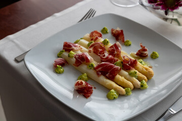 Colorful Salad with White Asparagus, Iberic Ham and Citrus Mayonnaise - Refreshing Summer Dish Served on Restaurant Table