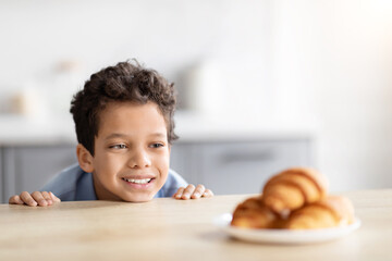 Boy eyeing croissants on the kitchen counter