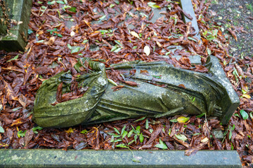 liegende gestürzte Statue im nassen Laub auf dem Highgate Cemetery in London Camden
