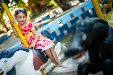 girl sitting on a carousel, horse carousel, abandoned park, children's entertainment, carousel for...