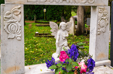 kleiner Engel in einem schönen Rahmen  mit Blumen auf dem Highgate Cemetery in London Camden
