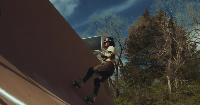 Slow motion of quad skater pumping and jumping on a tall half-pipe. Corey Lawrence Vert Ramp, Lawrence, Kansas, USA.