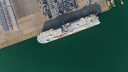 Aerial drone photo of large car carrier ro ro vessel guided by tug boats to dock to Mediterranean port. - obrazy, fototapety, plakaty