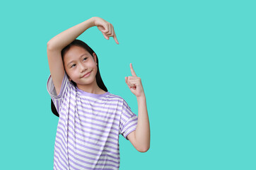 Asian girl child showing at copy space with pointing up and down and look beside for ads advertising on cyan. Image with Clipping path. - 793794812