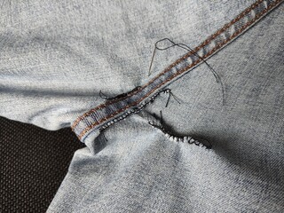 Hand-sewn holes on jeans, seams from sewing on the inside of denim
