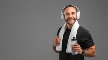Man Wearing Headphones and Holding a Bottle of Water