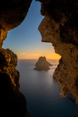 Es Vedra and Es Vendrell islets view through a rock hole in a cave at sunset, Sant Josep de Sa Talaia, Ibiza, Balearic Islands, Spain