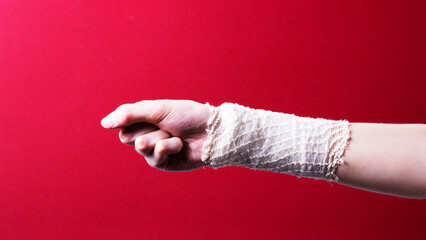 a bandaged female hand on a colored background