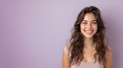 Portrait of a cheerful young woman wearing casual t-shirt standing isolated over light purple background, looking at camera
