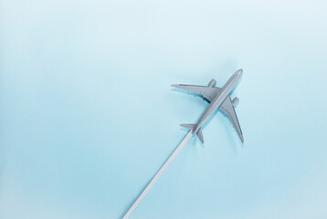 Airplane model in flight on a blue background copy space. Travel concept.
