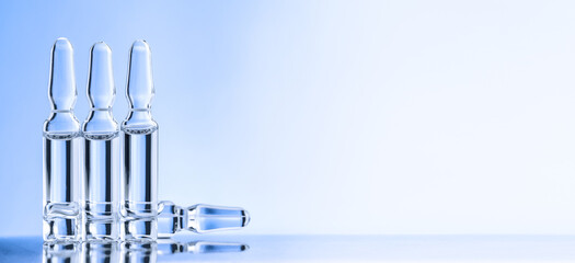 Four ampules over desk on blue background. Concept of medicine