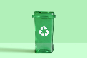 Glass garbage bin on studio green  background