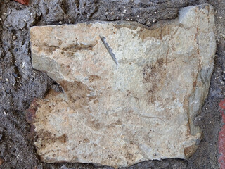 Rough, rough close-up view of the worn, textured surface of natural stone