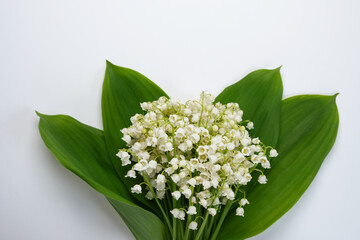 May flowers. Bouqet of lily of the valley flowers on white background. Top view, flat lay.