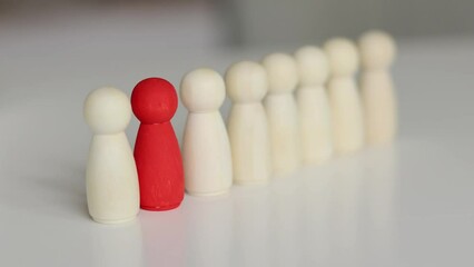 Leadership, career growth concept. Red figure in row of many wooden people figures.