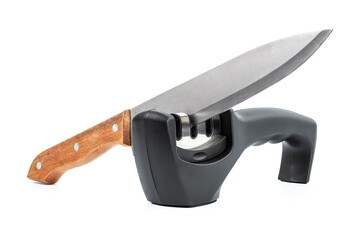 knife with sharpener on the table. Knife and knife sharpener on a white surface. Kitchen tools isolated on white background. Reversible manual knife sharpener. 