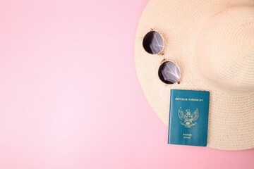 Passport and Sunglasses on Beach Hat Isolated on Pink Background for Travel Around The World...