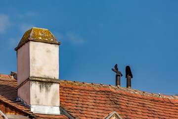 Roofs and top parts of buildings in Sibiu, Romania on blue sky background with copy space