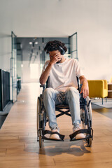 A African-American teenager in a wheelchair sits sadly amidst the bustling backdrop of a modern...