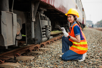 Train locomotive engineer women worker. Young teen Asian working check service maintenance train using tablet computer software.