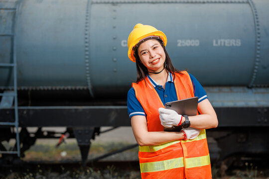 portrait train locomotive engineer women worker. young Asian teen happy smiling enjoy working check service maintenance train with tablet.