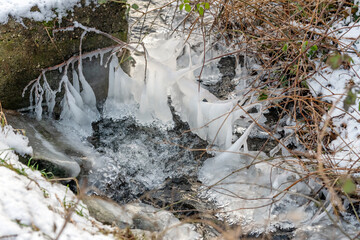 Icicles on the rocks in the spring forest.