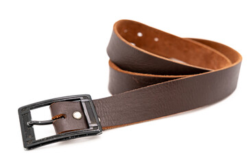 Worn Men's leather belt in a dark brown color with a metal buckle on white background. Selective focus, close-up.