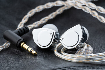 In ear monitor on a tablature background. Custom in-ear monitors with black plates. Custom in ear...