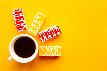 Delicious color bright cakes and coffee cup. Bright yellow background, minimal concept.