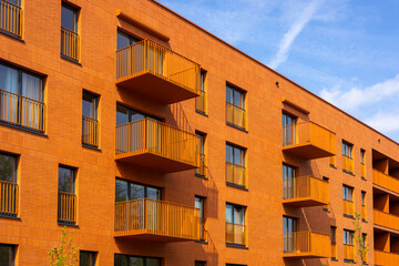 Modern apartment buildings on a sunny day with a blue sky. Orange Facade of a modern apartment building.