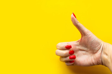 Woman's hand shows the super gesture over bright yellow background. Minimal concept. Copy space for the text