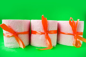 toilet paper rolls wrapped in gift bows on green background. Covid19 concept.