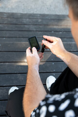 Men checking their sugar levels using a lancet pen and a glucometer in the city