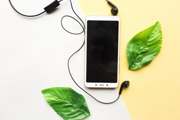 Mobile phone with black mockup screen and coffee cup on yellow background. Minimal concept.