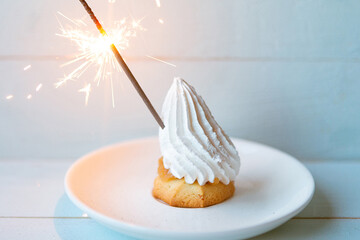 cream cake with sparkler on blue background