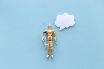 Wooden figurine of a man with syringe and vaccine. Medicine and healthcare concept - 793861884