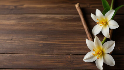 Fototapeta na wymiar Vanilla sticks with flower and leaf on a white wooden background