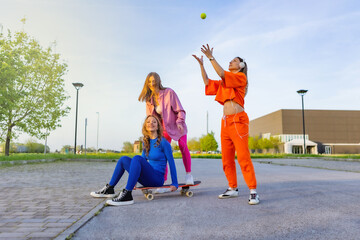 Ragazze in città che si divertono correndo sullo skateboard.