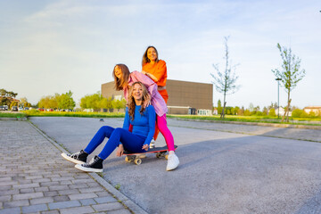 Ragazze in città che si divertono correndo sullo skateboard.