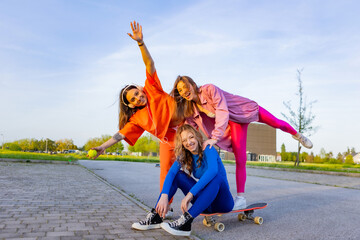 Ragazze in città che si divertono correndo sullo skateboard.