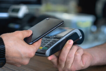Customer making wireless or contactless payment using credit card. Cashier accepting payment over nfc technology. E-banking, e-commerce, non-cash cashless purchases. Cashback transactions