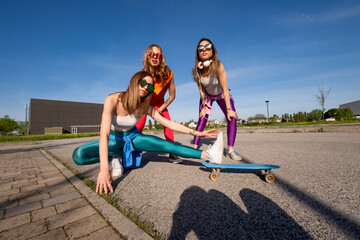 Ragazze in città che si divertono correndo sullo skateboard.