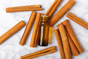 Cinnamon aromatic essential oil and cinnamon sticks on a wooden background. Aromatherapy. Organic cosmetic oil. Spa concept. Place for text. Copy space.