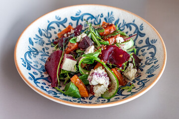 Sumptuous beetroot salad, tangy feta, quinoa sprinkle, in a handcrafted blue-patterned bowl. Vibrant, healthy gastronomy with an artisanal touch.