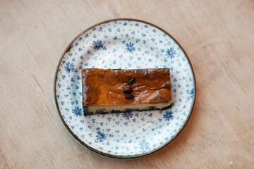A piece of espresso macadamia cheese cake topped with coffee beans on the plate.