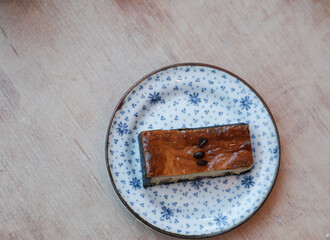 A piece of espresso macadamia cheese cake topped with coffee beans on the plate.