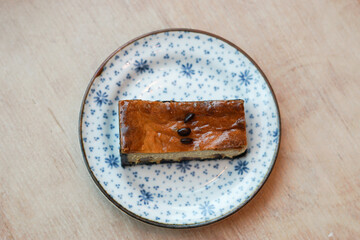 A piece of espresso macadamia cheese cake topped with coffee beans on the plate.